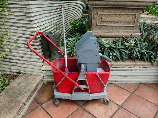 Wringer mop bucket down press cleaning janitor trolley stand at the corner of the park.